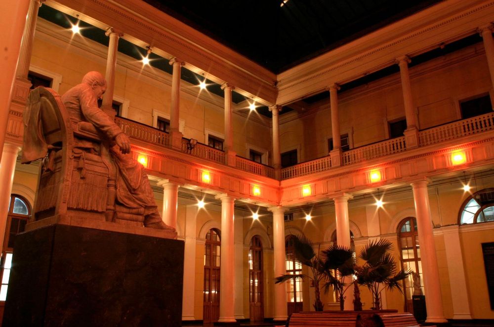 En la imagen se puede ver parte del Patio Bello en Casa Central con diferentes luces puestas para la exposición artística del profesor Gonzalo Díaz.